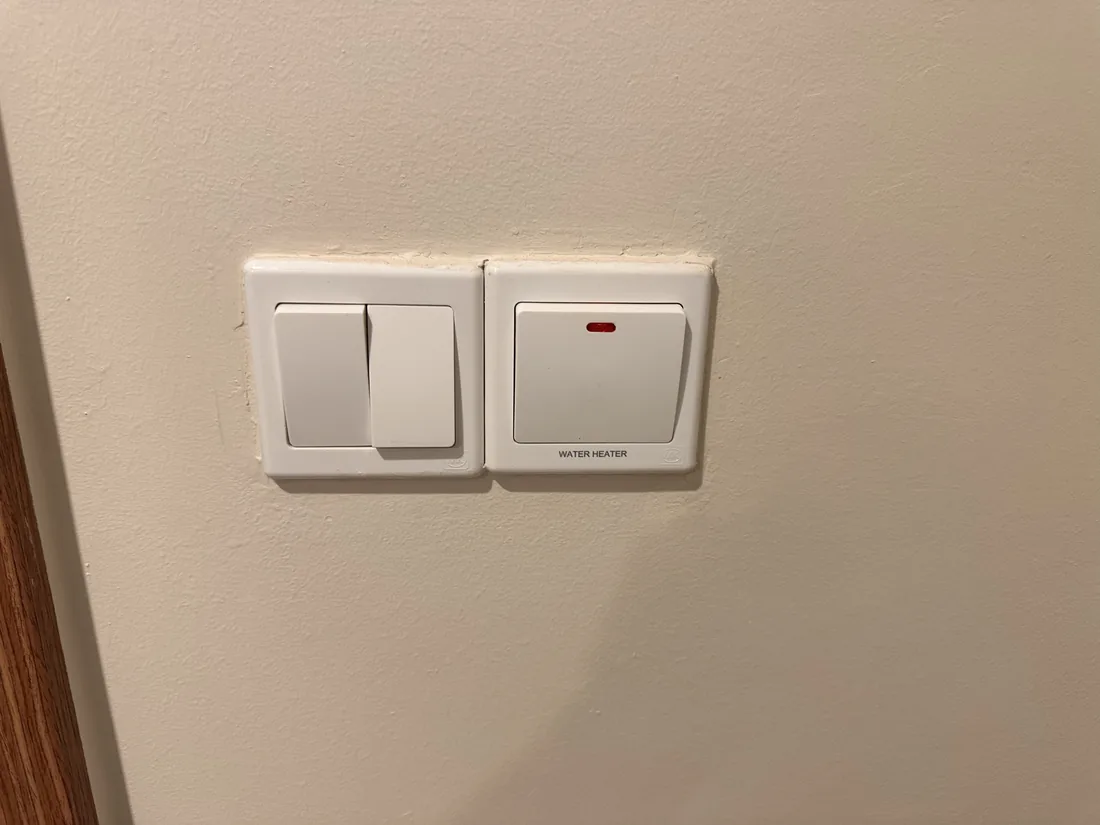 Two conventional white wall switch plates on a plain wall.