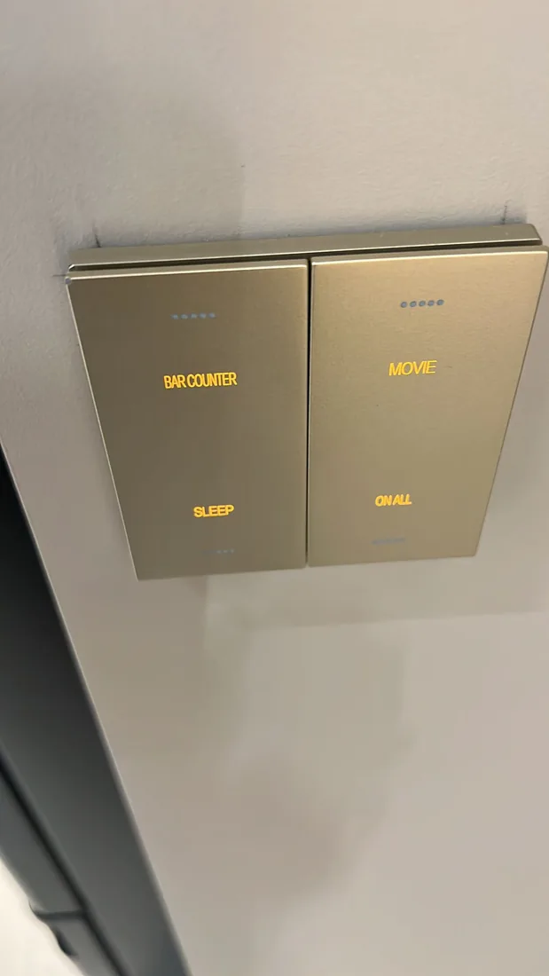 A champagne-finish scene switch engraved with Bar Counter, Sleep, Movie and On All, lit in amber.