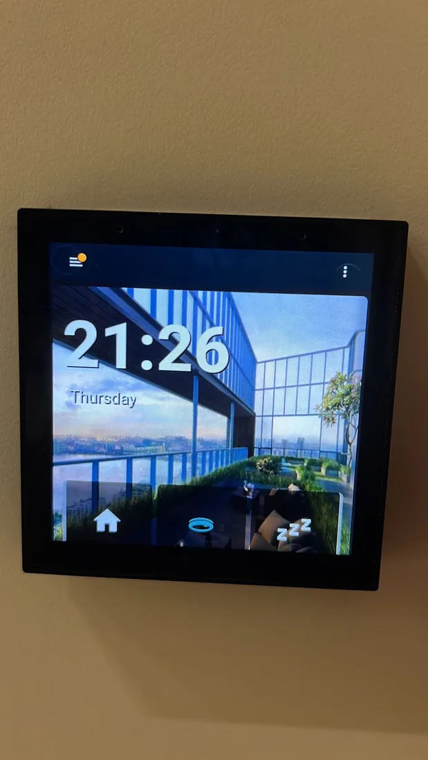 A wall-mounted tablet showing a home dashboard with the time and room controls.