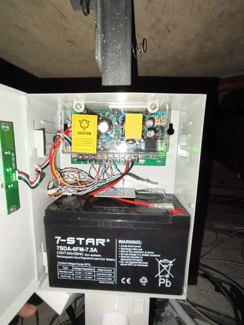 An open access-control enclosure containing a control board and a sealed backup battery.
