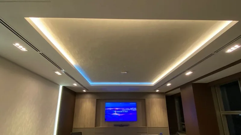 A meeting room with concealed cove lighting and a wall display.