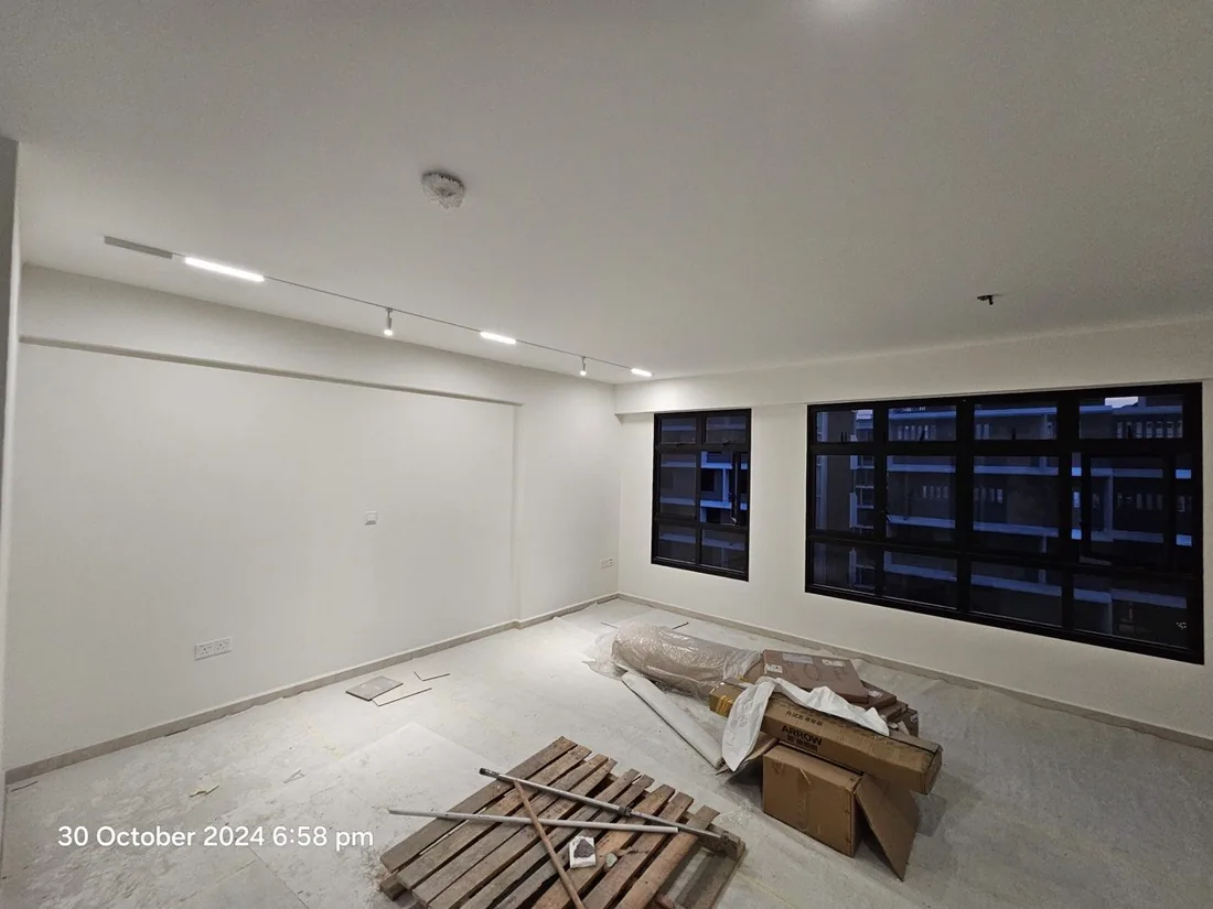 An empty HDB flat during renovation, before finishes, with a wall-mounted air conditioner.