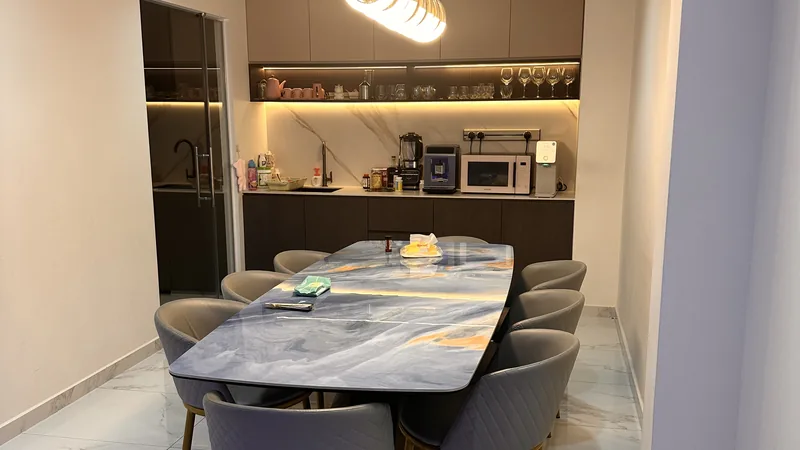 Open-plan dining and kitchen in a landed home under pendant and cove lighting.