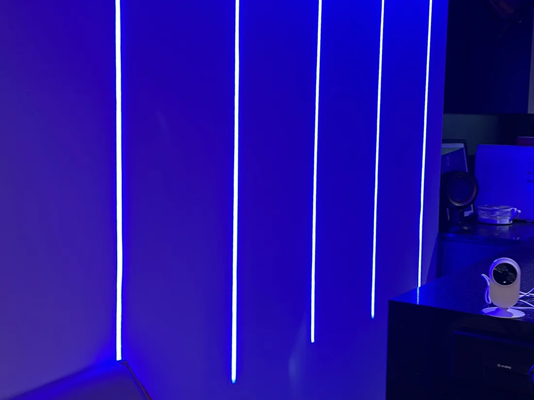 Close view of vertical WLED strips lit blue beside a console