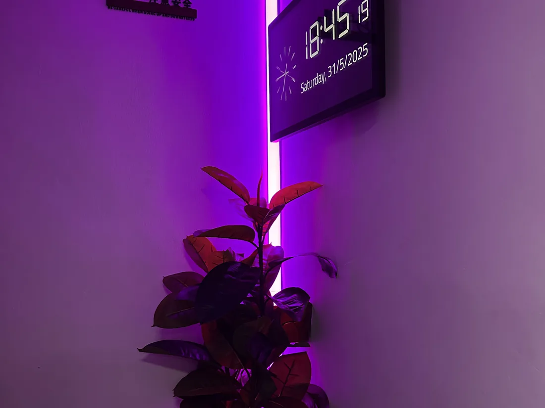 Magenta WLED strip beside a smart wall clock showing the time and date